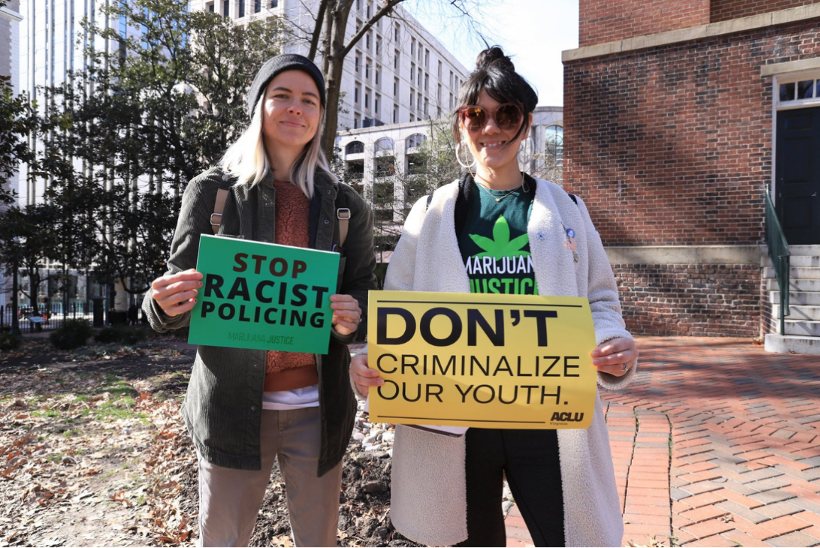 two protesters holding signs that say "Stop racist policing" and "Don't criminalize our youth"