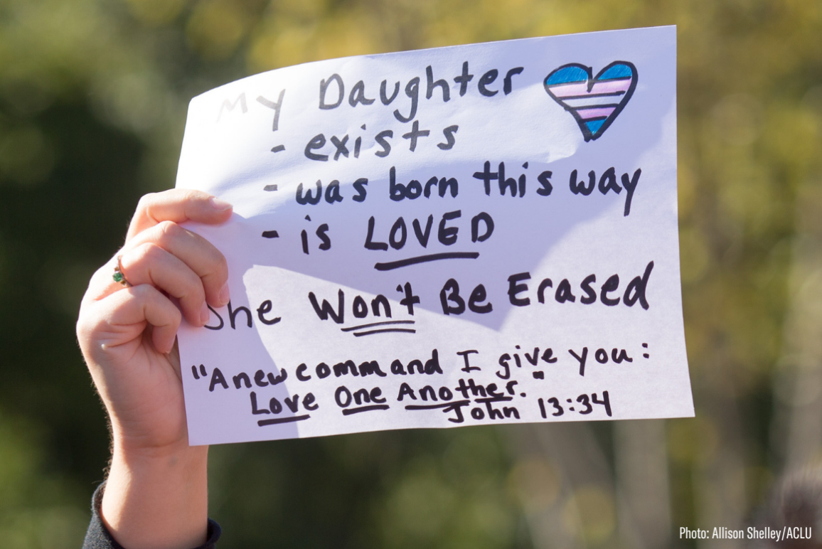a protest sign with the message: My daughter exists, was born this way, is LOVED. She won't be erased.
