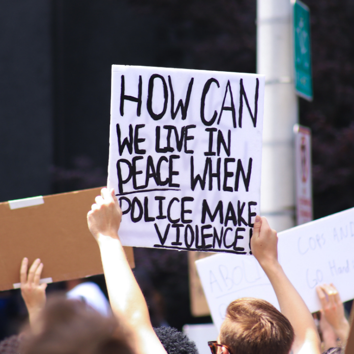 a protest sign with the text "how can we live in peace when police makes violence"